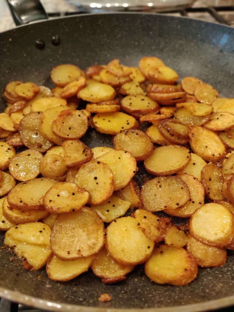 Potatoes sautéed in pan with oil and seasoning