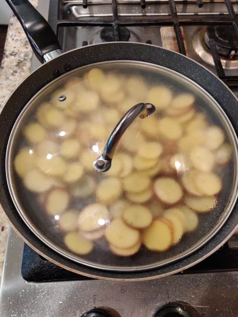 Covered pan with potatoes on stove