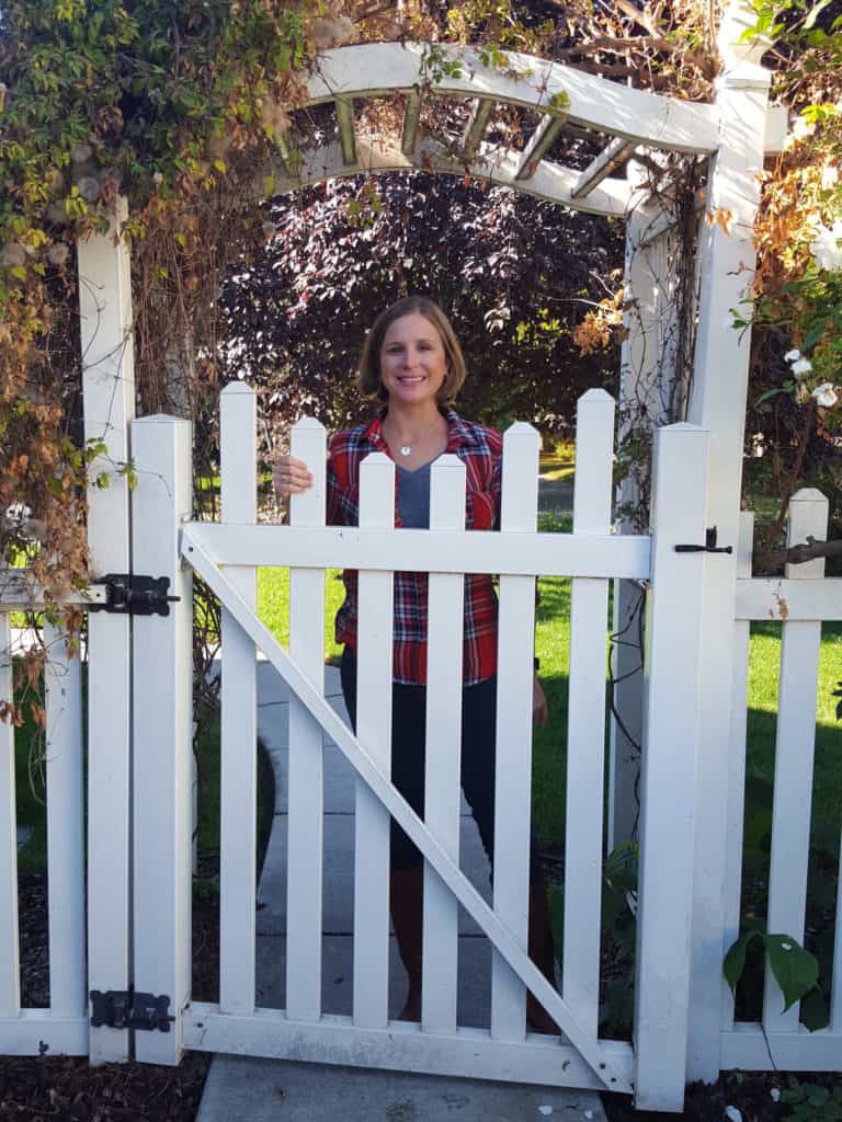 Mindee standing behind a white gate