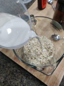Pouring milk into bowl with oats