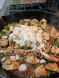 Water chestnuts on top of cooked veggies and chicken