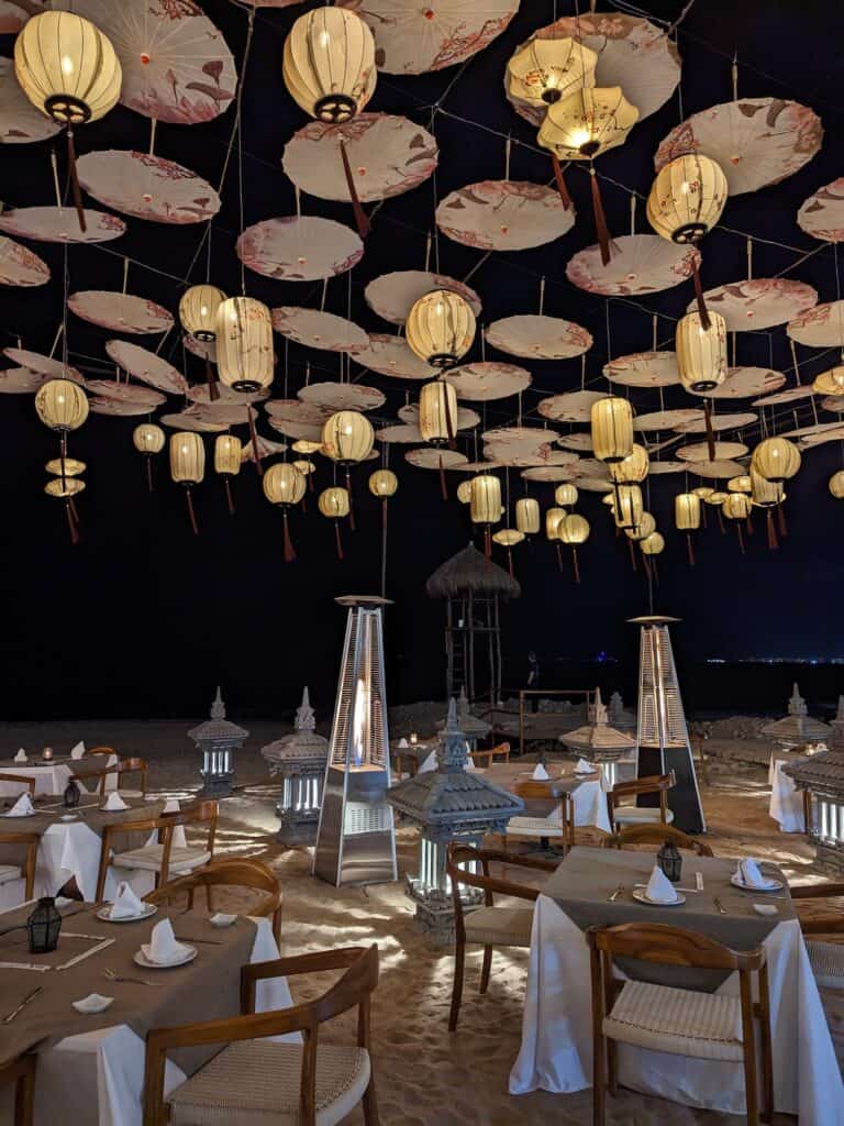 Floating lights above the tables on the beach for dinner