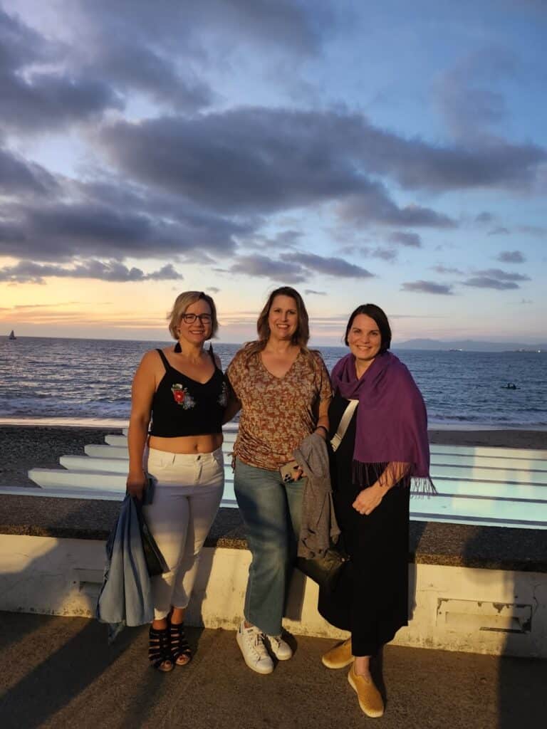 Friends standing on the Malecon walkway with the ocean in the background
