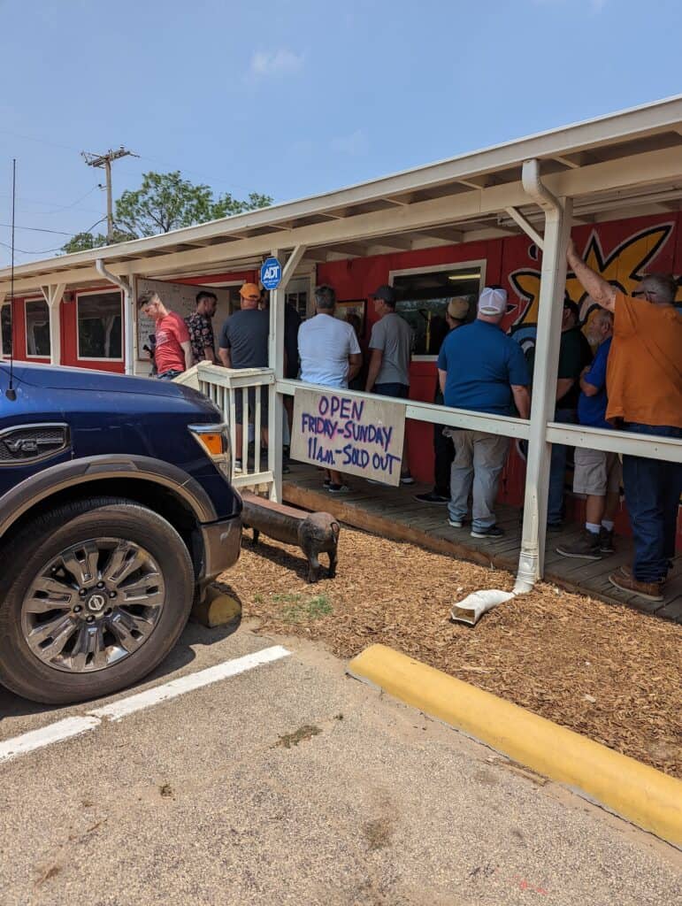 Line on the porch of goldees BBQ